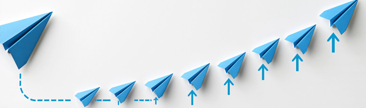 Paper Airplanes Ascending: A series of blue paper airplanes launch upwards in a staircase pattern, symbolizing progress, innovation, and the pursuit of ambitious goals.