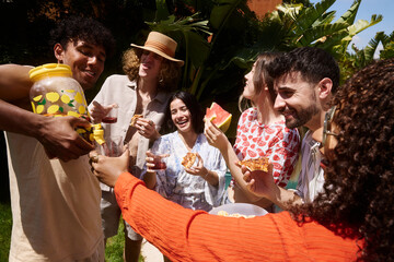 Obraz premium Group of friends enjoying summer garden party outdoors