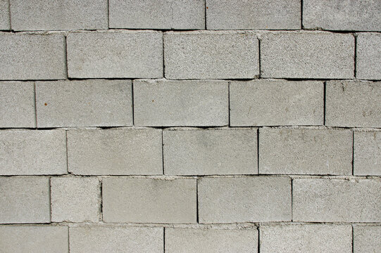 Grey unfinished wall built with blocks.