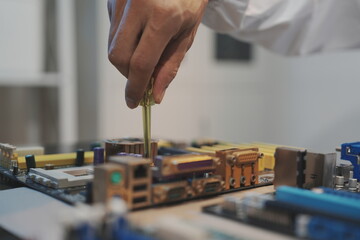 Obraz premium A technician's gloved hand works with a screwdriver on a motherboard CPU socket area, shown from an eye-level perspective. Dismantled hard drives.