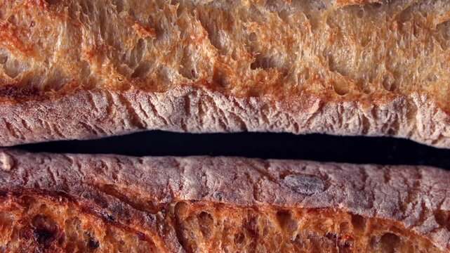 Rustic Baguette Crust Close Up. Macro close-up of rustic baguette crust with golden crispy texture and flour dusting on a dark background.