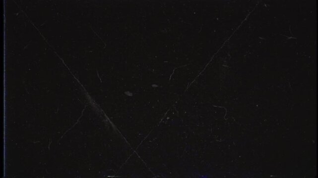 Abstract dark background with floating particles in low light.