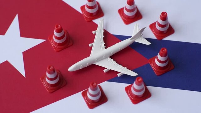 A mock up of airplane surrounded by no fly signs on a Cuba flag as a concept for a flight ban or cancellation