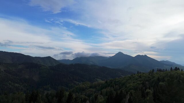 Aerial Drone Video Flying Backward Revealing Carpathian Mountain Panorama with Rocky Peak and Dramatic Cloudy Sky