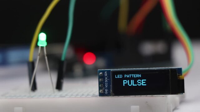 OLED screen displaying different LED lighting patterns while a green LED in the background demonstrates each pattern in real time