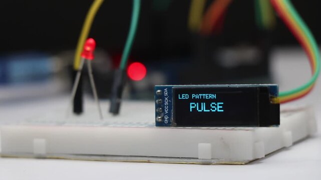 OLED screen displaying the active LED lighting pattern with a glowing red LED diode illuminating in the background