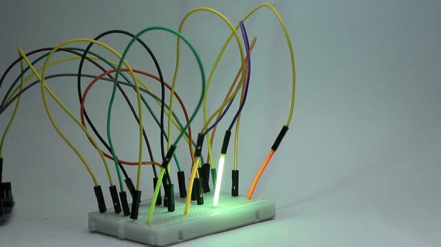 Microcontroller based electronics project with LED filament tubes on a breadboard connected via jumper wires and programmed to glow in sequence