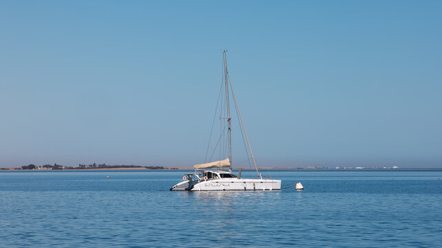 Walvis Bay, Namibia - May 26, 2025: Sailboat anchored peacefully in Walvis Bay Namibia under clear blue sky