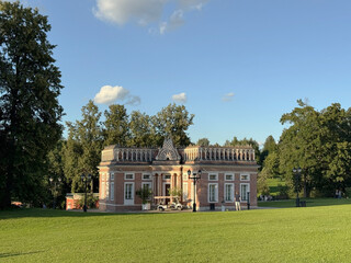 Small neoclassical building in park setting under clear sky suitable for background use © dvoevnore