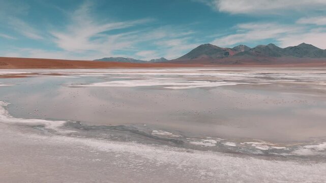 Aerial view of a turquoise Andean lagoon surrounded by volcanic peaks in the remote landscapes of Bolivia&rsquo;s Sud L&iacute;pez region.