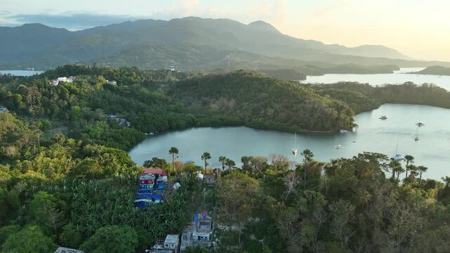 Aerial view of forested Puerto Galera bays with boats and mountain coastline