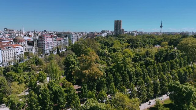 Wide drone shot of Retiro Park with Torrespa&ntilde;a and Madrid buildings beyond