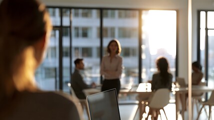 Obraz premium A professional figure is seen from the back bathed in natural daylight streaming through large office creating a sense of strategy and modern