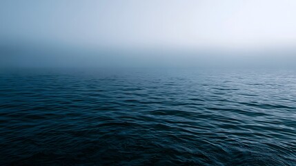 Fototapeta premium A serene blue sea view is softly shrouded in diffused ethereal foggy light creating a tranquil and romantic atmosphere