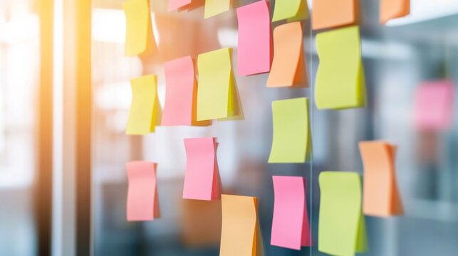 Vibrant array of pink, yellow, green sticky notes on glass, sunlight flares, symbolizing brainstorming and agile project management, Office ,Ideas