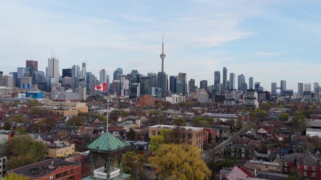 Canadian flag waving over Toronto with CN Tower and downtown skyline, city's financial district, residential neighborhoods, urban architecture
