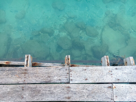 The wooden planks overlook the crystal-clear sea.