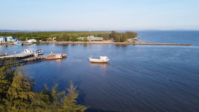 A drone perspective capturing a wide panorama of the shoreline where the river meets the sea, with a military landmark on the distant coast