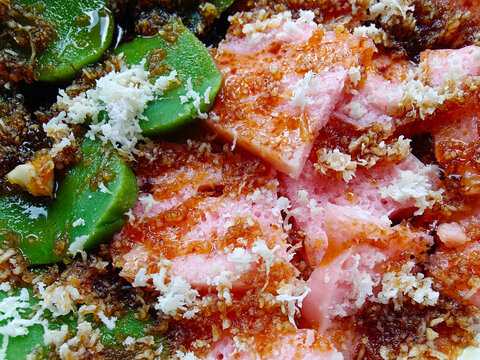 Close up look of lupis and cenil traditional Indonesian sweet rice cake sprinkled with grated coconut and liquid palm sugar
