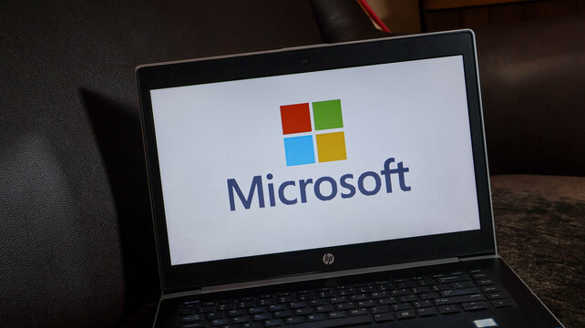 Microsoft logo displayed on a laptop screen with a black keyboard and frame