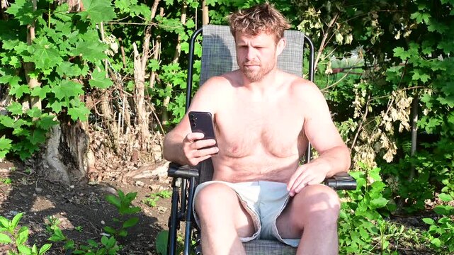Man sunbathing outside putting phone away, disconnecting from social media concept