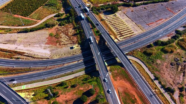 Traffic on highways in a rural area. Vehicles travel on highways surrounded by fields and open land during daylight.