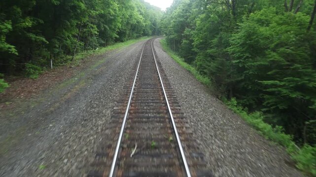 view of moving train tracks from the back of metro car window new york jersey transit north (riding subway travel transportation) gravel rail track bed