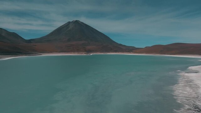 Aerial view of a turquoise Andean lagoon surrounded by volcanic peaks in the remote landscapes of Bolivia&rsquo;s Sud L&iacute;pez region.