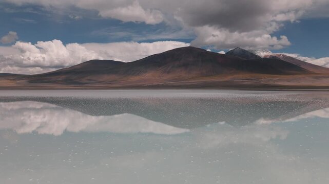 Aerial view of a turquoise Andean lagoon surrounded by volcanic peaks in the remote landscapes of Bolivia&rsquo;s Sud L&iacute;pez region.