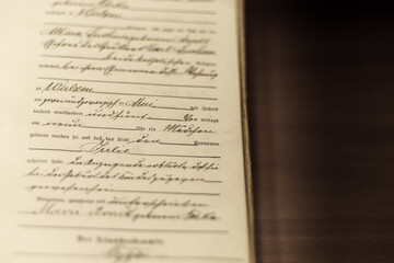 Zbliżenie na stary niemiecki dokument z odręcznym pismem (kurrenta). Detal aktu urzędu stanu cywilnego, płytka głębia ostrości. Vintage tło historyczne, archiwalne i genealogiczne.