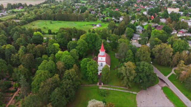 Drone Establishing Shot of Historic Skrunda Church and Green Town Landscape
