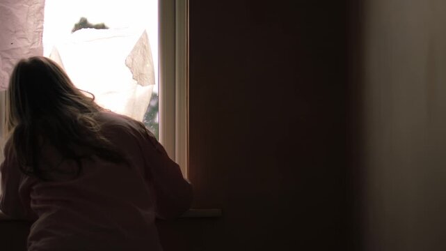 Woman looking through window through view of door