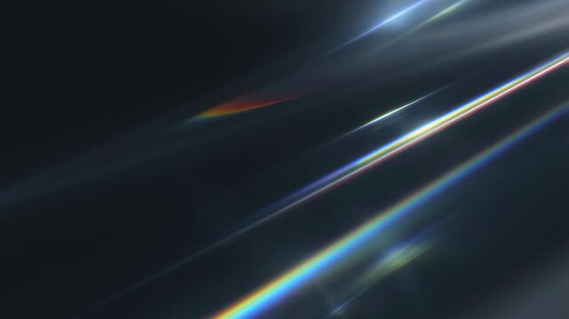 Slow motion tracking shot of prismatic light streaks gliding across dark reflective surface with subtle lens flare in abstract studio background
