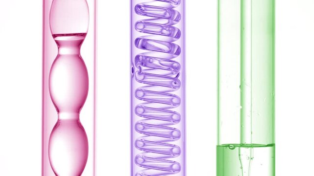 Three upright lab glassware pieces with pink, violet, green liquids filling the bulb condenser, bubbling, flowing through the glass coil condenser and filling the tube flask via dropper on a white bg