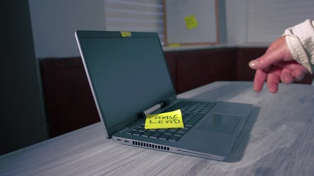 Woman throws reminder note onto laptop