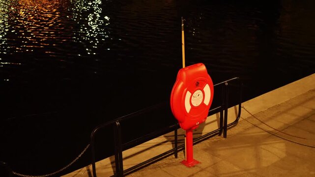 Static shot of a lifebuoy by a canal at night. Gdansk, Poland.