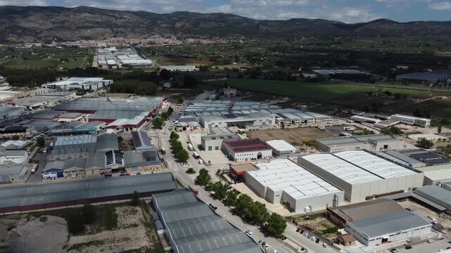 Aerial reveal of the industrial park of Castalla, Spain. Town of Onil in the background.