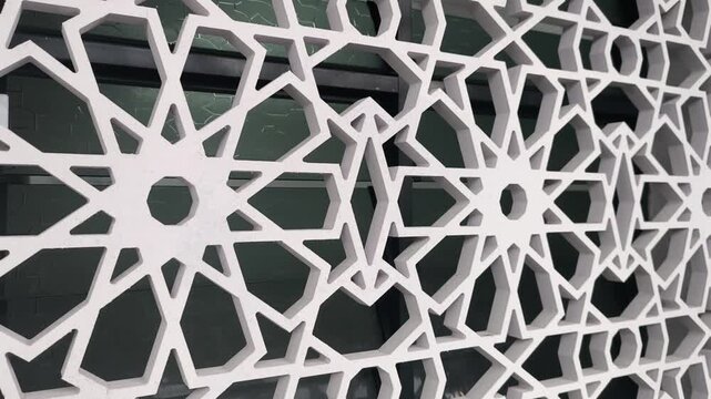An Islamic geometric pattern serves as a ventilation wall on a building. Made from GFRC, the perforated screen allows airflow while maintaining interior privacy. It combines beauty and function.