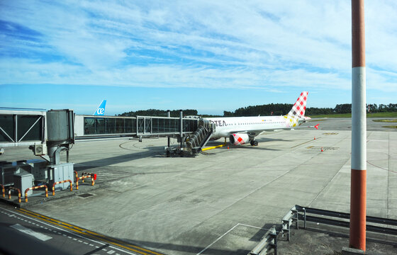 Puente de embarque de pasajeros para un avi&oacute;n Airbus perteneciente a la aerol&iacute;nea espa&ntilde;ola de bajo coste Volotea en la pista del Aeropuerto de Asturias. Principado de Asturias, norte de Espa&ntilde;a.