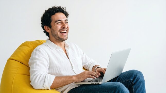 Man laughing while working on laptop with bright studio lighting and copy space