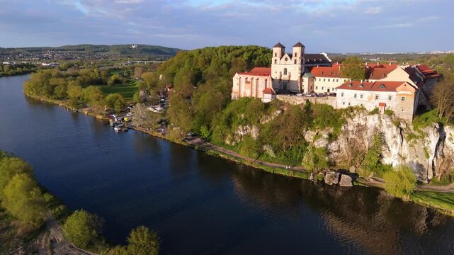  Aerial flyover of an abbey on a river in Poland at sunset in spring