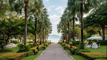 Obraz premium Lush Palm Tree Lined Pathway Leading to Serene Ocean View and Beachfront Resort.