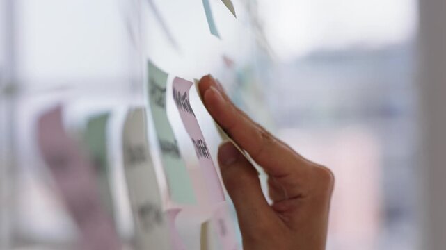 Hands, glass wall and sticky note at office with project management, planning or review at startup. Person, paper and link for solution, proposal or problem solving with schedule at creative agency