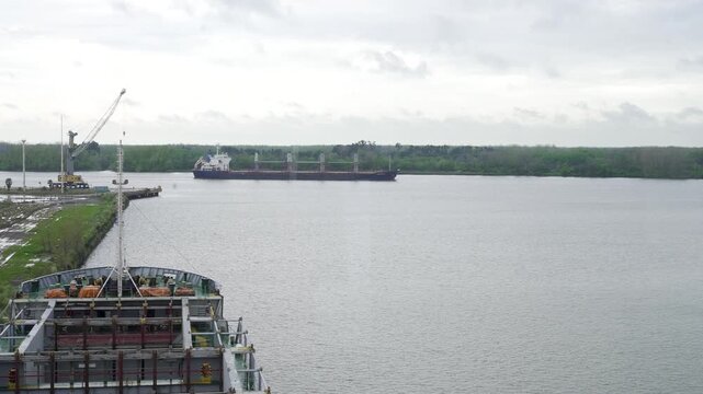 Barco navegando por un r&iacute;o durante un d&iacute;a lluvioso, visto desde el puente de mando de otra embarcaci&oacute;n, transporte fluvial, navegaci&oacute;n, industria mar&iacute;tima y clima adverso