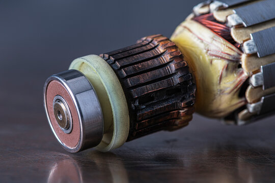 Damaged commutator from a brushed electric motor, burnt contacts, darkened segments, and signs of electrical wear and overheating