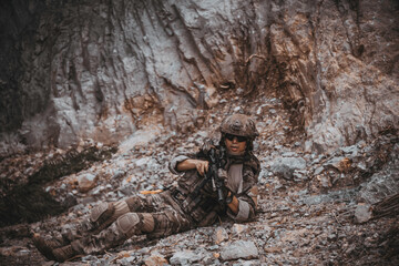 Obraz premium Armed tactical operator aiming rifle during military combat mission in outdoor nature environment. Professional private military contractor conducting security patrol operation in forest wilderness.