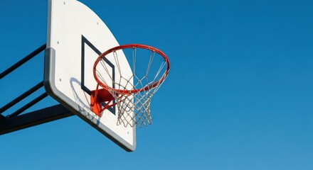 Naklejka premium Close-up of a basketball hoop against a clear, azure sky backdrop