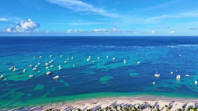 Tropical resort beach with thatched umbrellas. Summer holidays and a luxurious holiday landscape. Tourist destination for recreation. White yachts on the blue sea.