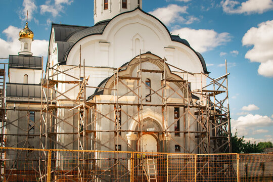 orthodox church restoration with golden dome and wooden scaffolding