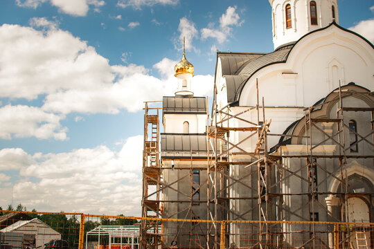 orthodox church restoration with scaffolding under blue sky
